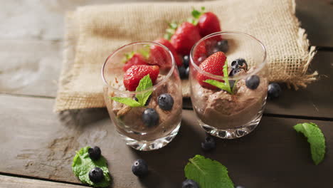 Video-of-chocolate-pudding-with-strawberries-and-bluberries-on-a-wooden-surface