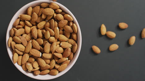 Video-of-fresh-fruit-almonds-in-a-bowl-on-grey-background