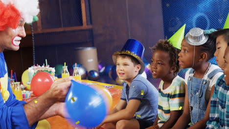 Animation-Von-Konfetti,-Das-über-Verschiedene-Kinder-Und-Clowns-Auf-Einer-Geburtstagsfeier-Fällt