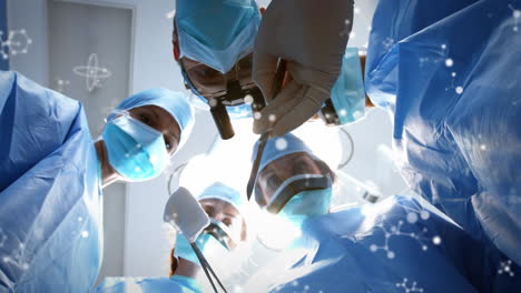 Animation-of-molecules-over-group-of-diverse-male-and-female-surgeons-at-surgery-room
