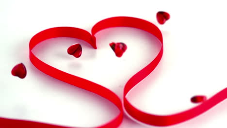 Animation-of-red-hearts-and-ribbon-over-white-background