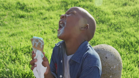 Video-Eines-Glücklichen-Afroamerikanischen-Jungen,-Der-An-Einem-Sonnigen-Tag-Eis-Isst-Und-Lacht