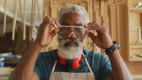Porträt-Eines-Afroamerikanischen-Zimmermanns-Mit-Schutzbrille-In-Einer-Tischlerei