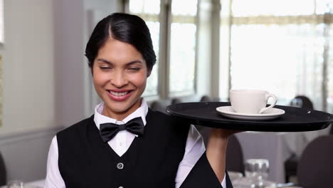 Pretty-waitress-holding-a-tray-with-a-cup