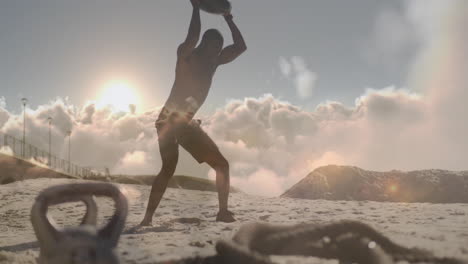 Animation-of-clouds-over-african-american-man-weight-training-on-beach