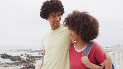 Afroamerikanisches-Junges-Paar-Lächelt-Einander-Zu,-Während-Es-Gemeinsam-Auf-Der-Promenade-Spaziert