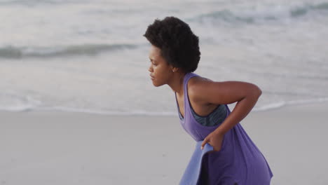 Afroamerikanische-Frau-Mit-Yogamatte-Am-Sonnigen-Strand