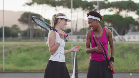 Video-of-happy-diverse-female-tennis-players-laughing-and-talking-after-match