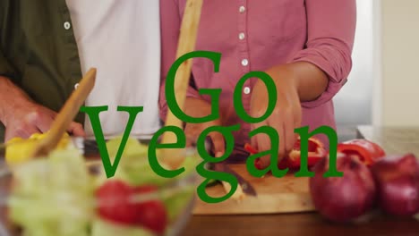 Animation-of-go-vegan-text-over-diverse-couple-cooking