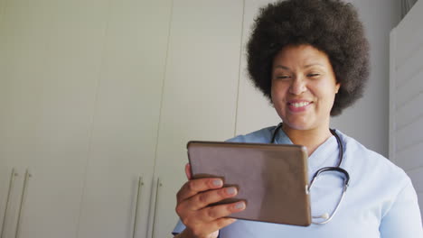 Video-Einer-Glücklichen-Afroamerikanischen-Ärztin-In-Übergröße,-Die-Ein-Tablet-Verwendet