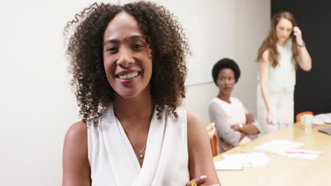 Portrait-of-biracial-businesswoman-with-her-diverse-colleagues-at-meeting-at-office,-in-slow-motion