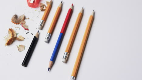 Close-up-of-pencils-and-pencil-sharpener-on-white-background,-in-slow-motion