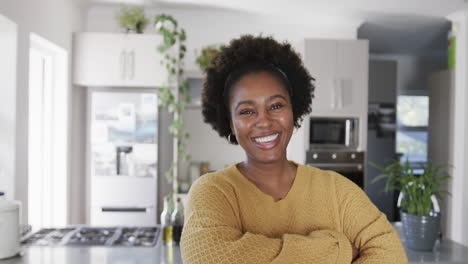 Portrait-of-happy-african-american-woman-smiling-in-kitchen,-in-slow-motion