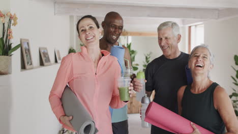 Portrait-of-happy-diverse-seniors-and-female-pilates-coach-with-drinks,-unaltered,-in-slow-motion