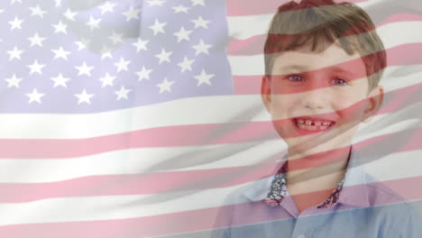Animation-of-american-flag-blowing-over-happy-caucasian-schoolboy-smiling-in-classroom