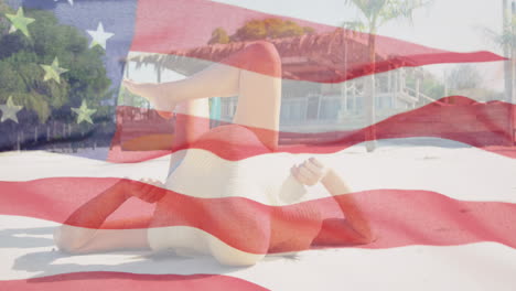 Animation-of-waving-flag-of-america-over-biracial-woman-relaxing-on-sunny-beach-for-independence-day