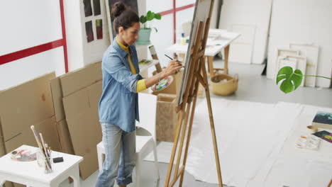 Video-of-biracial-female-artist-painting-in-studio