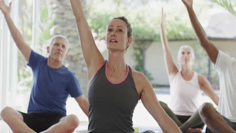 Focused-diverse-seniors-exercising-in-pilates-class-with-female-coach,-unaltered,-in-slow-motion