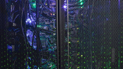 Animation-of-looping-binary-codes-over-illuminated-back-panel-of-data-server-machine-in-server-room