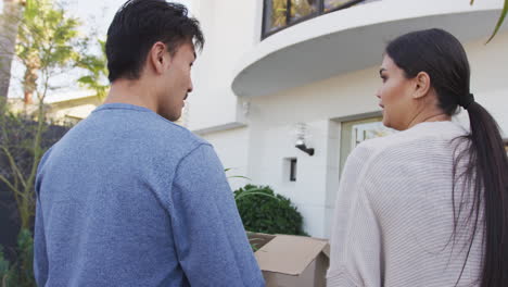 Video-of-back-view-of-diverse-couple-walking-into-new-house