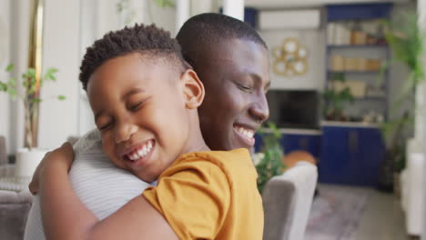 Video-Eines-Glücklichen-Afroamerikanischen-Vaters-Und-Sohnes,-Der-Sich-Zu-Hause-Umarmt