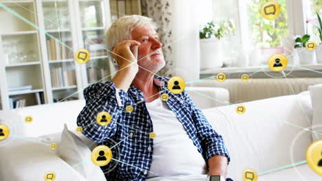 Animation-of-network-of-digital-icons-against-caucasian-senior-man-talking-on-smartphone
