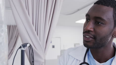 Glücklicher-Afroamerikanischer-Arzt,-Der-Den-Tropf-Im-Krankenhauszimmer-überprüft,-Zeitlupe