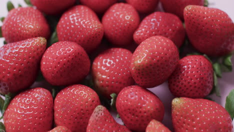 Video-of-close-up-of-strawberries-over-pink-background