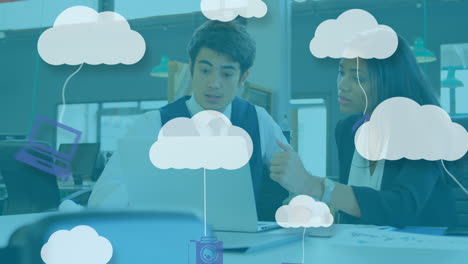 Animation-of-graphical-clouds-and-computer-icons-over-multiracial-colleagues-discussing-over-laptop