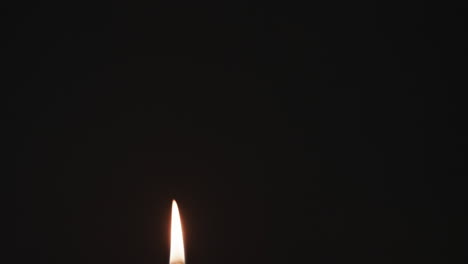 Video-of-green-candle-with-white-flame-and-copy-space-on-black-background