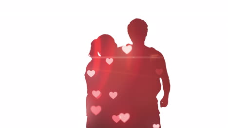 Animation-of-hearts-falling-over-silhouette-of-couple-embracing