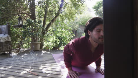 Kaukasischer-Mann-Praktiziert-Yoga-Auf-Der-Terrasse-In-Sonniger-Natur,-Kopierraum,-Zeitlupe