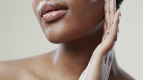 Lippen-Einer-Afroamerikanischen-Frau-Mit-Kurzen-Dunklen-Haaren-Auf-Beigem-Hintergrund,-Zeitlupe