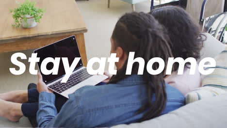 Animation-Von-„Stay-At-Home“-Text-über-Ein-Biraciales-Paar-Mit-Laptop