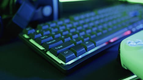 Video-of-gaming-computer-and-gaming-equipment-on-desk-with-copy-space-on-neon-background