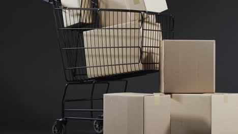 Video-of-shopping-trolley-and-boxes-with-copy-space-over-grey-background