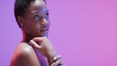 African-american-woman-with-short-dark-hair-in-blue-and-pink-light-with-copy-space,-slow-motion