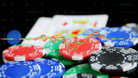Animation-of-financial-data-processing-over-playing-cards-and-chips-on-black-background