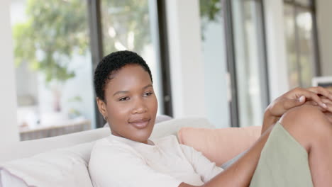 Happy-african-american-woman-with-eyes-closed,-sitting-on-sofa-and-relaxing,-slow-motion