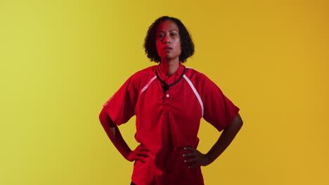 Portrait-of-african-american-female-rugby-player-over-neon-yellow-lighting