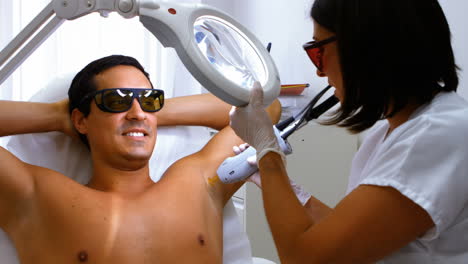 Doctor-performing-laser-hair-removal-on-male-patient-skin