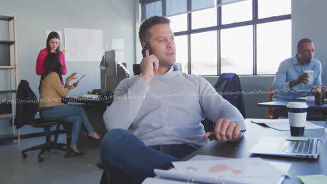 Animation-of-abstract-pattern-over-caucasian-businessman-talking-on-smartphone-in-office