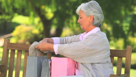 Mature-woman-on-a-park-bench-with-her-shopping