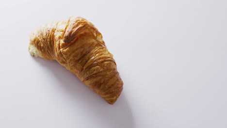 Video-of-close-up-of-croissant-with-copy-space-on-white-background
