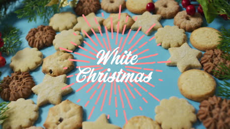 Animation-of-white-christmas-over-cookies-on-blue-surface