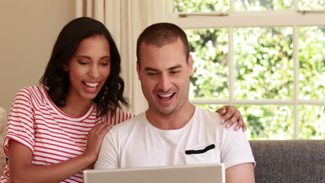 Happy-couple-using-laptop