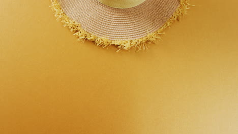 Video-of-close-up-of-hat-on-yellow-background