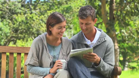 Young-couple-doing-crosswords-on-a-bench