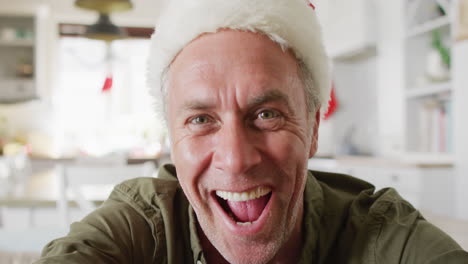 Glücklicher-Kaukasischer-Mann-Mit-Weihnachtsmannmütze,-Der-Einen-Videoanruf-Führt