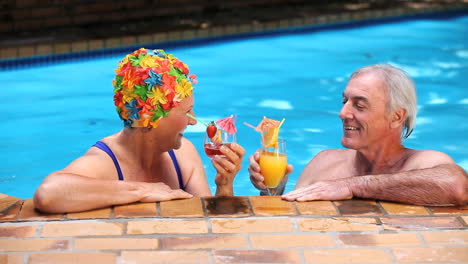 Senioren-Stoßen-Mit-Cocktails-Im-Pool-An